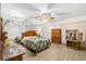 Spacious main bedroom with mirrored wall, leaf fan, wood-look flooring, and ample natural light at 2379 Finlandia Ln # 21, Clearwater, FL 33763