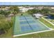 Overhead shot of well-maintained tennis courts with green fencing and a nearby lake at 2379 Finlandia Ln # 21, Clearwater, FL 33763