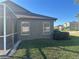 Rear exterior view highlighting the screen lanai with tidy landscape at 30142 Sotogrande Loop, Wesley Chapel, FL 33543