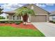 Inviting home featuring a two-car garage, tidy landscaping and a red front door at 30142 Sotogrande Loop, Wesley Chapel, FL 33543