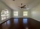 Bright living room boasts hardwood floors, large windows, and a ceiling fan at 30142 Sotogrande Loop, Wesley Chapel, FL 33543