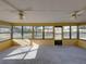 Relaxing sunroom with multiple windows offering views of the surrounding landscape, plus ceiling fans to keep it comfortable at 38847 Centennial Rd, Dade City, FL 33525