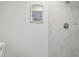 Bright bathroom featuring a modern shower with marble-like tiles and a sleek, minimalist design with a mirror at 4209 Westwood Dr, Holiday, FL 34691