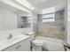 Bathroom with white tiling, toilet, vanity, and a shower-tub combo at 4209 Westwood Dr, Holiday, FL 34691