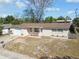 Single-story home with attached garage, featuring brick accents and manicured flower beds at 4209 Westwood Dr, Holiday, FL 34691