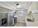 Modern kitchen featuring stainless steel appliances, white cabinets, and tile flooring, a sleek design at 4209 Westwood Dr, Holiday, FL 34691