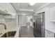 Updated kitchen with stainless steel appliances, white cabinetry, and tile floors, offering a modern, clean look at 4209 Westwood Dr, Holiday, FL 34691
