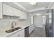 Bright kitchen with white cabinets, quartz countertops, stainless steel appliances and wood-look floors at 4209 Westwood Dr, Holiday, FL 34691
