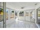 Bright sunroom featuring wood-look tile flooring, multiple windows, and a ceiling fan at 4209 Westwood Dr, Holiday, FL 34691