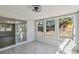 The sunroom has wood-look tile flooring and views of the backyard through large windows at 4209 Westwood Dr, Holiday, FL 34691