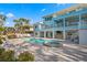 Expansive backyard features a pool, spa and multiple seating areas with waterfront views and a lush tropical landscaping at 440 Capri Blvd, Treasure Island, FL 33706