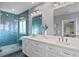 Modern bathroom features a glass shower, double sink vanity, and stylish blue tile at 440 Capri Blvd, Treasure Island, FL 33706