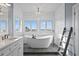 Luxurious bathroom with soaking tub, white shiplap walls, and a bright window view at 440 Capri Blvd, Treasure Island, FL 33706