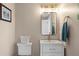 Powder room features a sleek vanity with modern fixtures, decorative mirror and sconces and neutral wall color at 440 Capri Blvd, Treasure Island, FL 33706