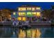 Stunning waterfront home with a private dock, boat, and beautifully illuminated exterior, perfect for evening enjoyment at 440 Capri Blvd, Treasure Island, FL 33706
