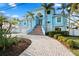 Beautiful waterfront home with a brick walkway, stairs, tropical landscaping, and a two-car garage at 440 Capri Blvd, Treasure Island, FL 33706