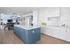 A modern kitchen features an island with a marble countertop, shaker cabinets, and stainless steel appliances at 440 Capri Blvd, Treasure Island, FL 33706