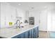 Bright kitchen features an island with marble countertop, shaker cabinets and stainless steel appliances at 440 Capri Blvd, Treasure Island, FL 33706