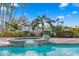 Outdoor pool and spa area surrounded by lush tropical landscaping, brick pavers and sunny skies at 440 Capri Blvd, Treasure Island, FL 33706