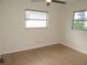Clean, empty bedroom with ceiling fan and light colored vinyl flooring at 4517 100Th N Ave, Pinellas Park, FL 33782