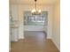 Bright dining room boasts modern chandelier, wood-look flooring and view to outdoors at 4517 100Th N Ave, Pinellas Park, FL 33782