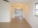 Hallway with light wood floors and neutral walls, illuminated by natural light coming through a nearby window at 4517 100Th N Ave, Pinellas Park, FL 33782
