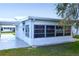 Exterior view showcasing the sunroom, connected carport and a well-maintained lawn, enhance this home's appeal at 4517 100Th N Ave, Pinellas Park, FL 33782