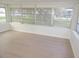 Bright sunroom featuring many large windows and light wood colored vinyl flooring at 4517 100Th N Ave, Pinellas Park, FL 33782