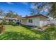 View of the backyard featuring a white brick home and well-maintained green lawn at 4814 Edmund Ct, Dover, FL 33527