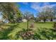 Expansive backyard with lush green grass and mature shade trees under a blue sky at 4814 Edmund Ct, Dover, FL 33527