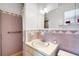 Well-lit bathroom featuring a sink vanity and a shower with an installed grab bar for accessibility at 4814 Edmund Ct, Dover, FL 33527