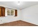 Neutral bedroom features a window with brown curtains, brown carpet, and white walls at 4814 Edmund Ct, Dover, FL 33527