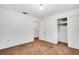 Neutral bedroom featuring a closet with white sliding doors, brown carpet, and access to bathroom at 4814 Edmund Ct, Dover, FL 33527