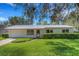 Charming single-story home with a metal roof, a lush green lawn, and a well-maintained brick facade at 4814 Edmund Ct, Dover, FL 33527