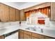 The kitchen has neutral cabinets, white appliances and countertops with a double sink under the window at 4814 Edmund Ct, Dover, FL 33527