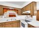 The kitchen has neutral cabinets, white appliances and countertops with a window above the sink at 4814 Edmund Ct, Dover, FL 33527