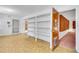 Storage area with many white shelves, vinyl flooring, and an open doorway to the home's interior at 4814 Edmund Ct, Dover, FL 33527