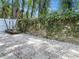 Serene backyard featuring stone pavers, white rock, and a lush vine-covered wall, creating a private outdoor space at 525 Lamara Ne Way, St Petersburg, FL 33704