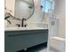 Beautiful bathroom with modern fixtures, dark green floating vanity, and a wall-mounted toilet at 525 Lamara Ne Way, St Petersburg, FL 33704