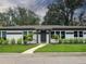 Charming single-story home featuring a well-manicured lawn, tidy shrubs, and symmetrical design elements at 525 Lamara Ne Way, St Petersburg, FL 33704