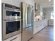 Close-up of modern stainless steel oven and refrigerator in a well-equipped kitchen with white cabinetry at 525 Lamara Ne Way, St Petersburg, FL 33704