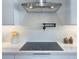 Close up on a modern kitchen stove with stainless steel hood and dark pot filler at 525 Lamara Ne Way, St Petersburg, FL 33704