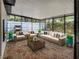 Inviting screened-in patio with comfortable seating, brick flooring, and lush green plants at 525 Lamara Ne Way, St Petersburg, FL 33704