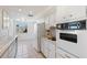 Functional kitchen with white appliances, upper and lower cabinets, and tile flooring at 5313 Mosaic Dr, Holiday, FL 34690