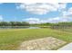 Scenic backyard with a brick patio, lush green lawn, and a serene view of the adjacent pond at 5955 Sweet Birch Dr, Riverview, FL 33578