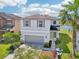 Charming two-story home with attached garage, a well-manicured lawn, and a view of the water at 5955 Sweet Birch Dr, Riverview, FL 33578