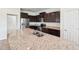 Kitchen island with granite countertops, stainless steel sink, and dark cabinets at 5955 Sweet Birch Dr, Riverview, FL 33578