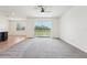 Open-concept living space, tile flooring, and access to the pond view through sliding glass doors at 5955 Sweet Birch Dr, Riverview, FL 33578