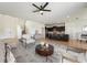 Open-concept living room flows into kitchen with seating and neutral decor; bright and inviting space at 5955 Sweet Birch Dr, Riverview, FL 33578