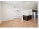Open-concept layout with kitchen island, stainless steel appliances, tile floors, and access to the living room at 5955 Sweet Birch Dr, Riverview, FL 33578